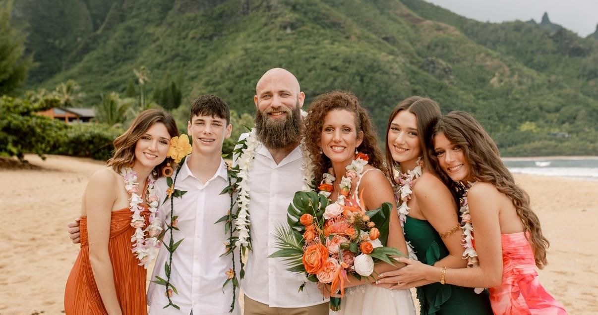 The Okie Fit Fam — Oklahoma family of six on a Hawaii beach wearing leis.